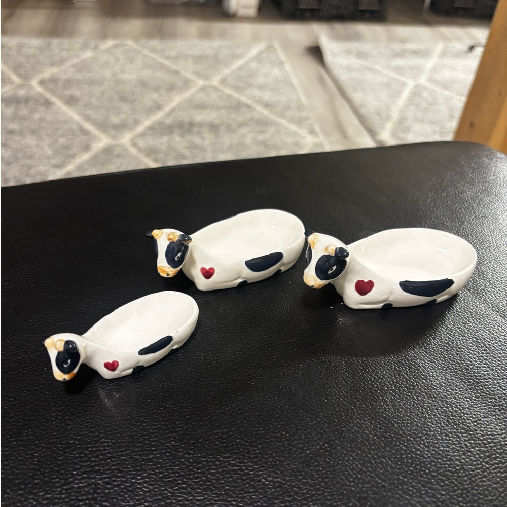 Three nesting cow measuring spoons marked 1987 CBQ LTD